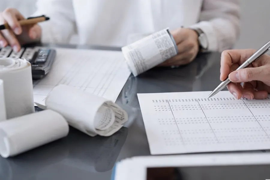 An advisor at a whiteboard drawing a timeline showing tax filing and invoice planning stages starting before company operations begin