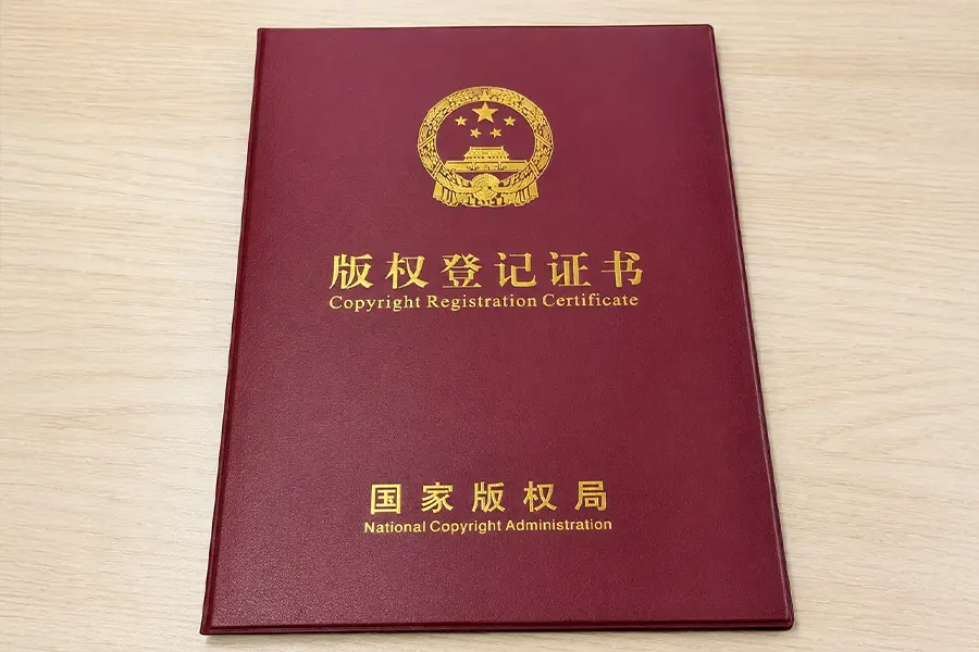 Copyright registration certificate with a creative work sample pinned beside it on a studio desk