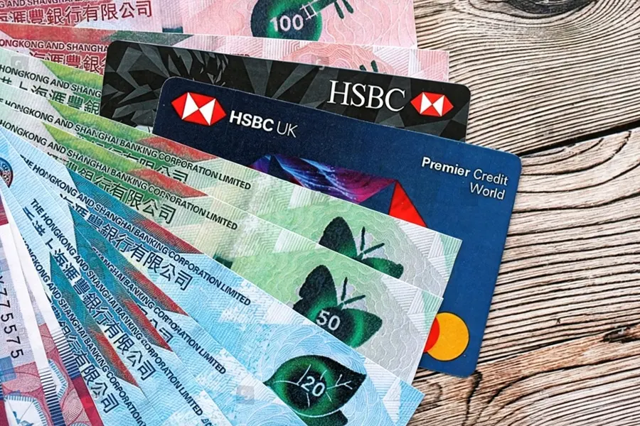 Founder at a Hong Kong bank holding a newly issued corporate bank card while completing account activation paperwork
