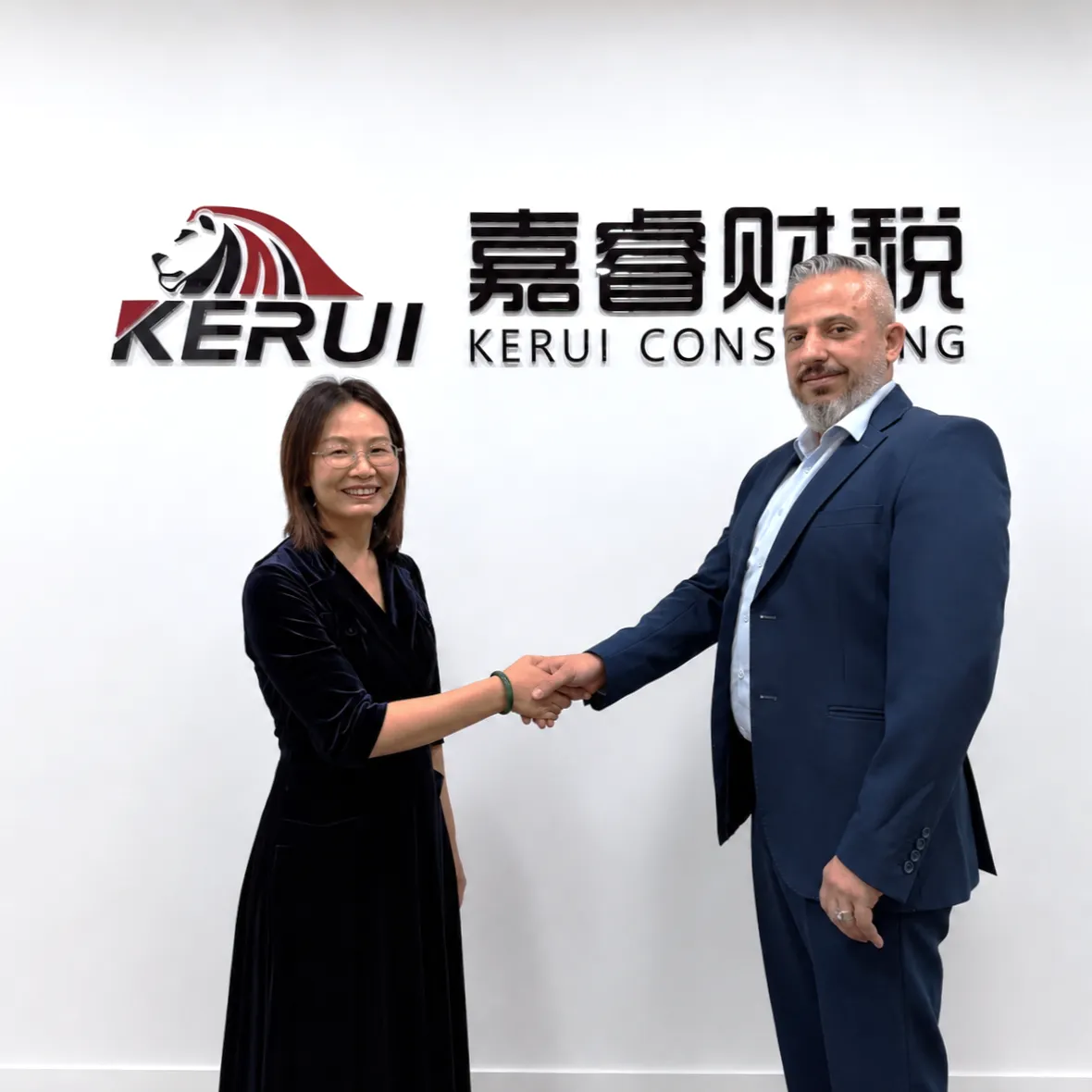 Kerui consultant shaking hands with a client in front of the Kerui Consulting logo